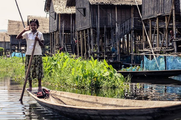 Local girl paddling boat on Inle Lake in Myanmar